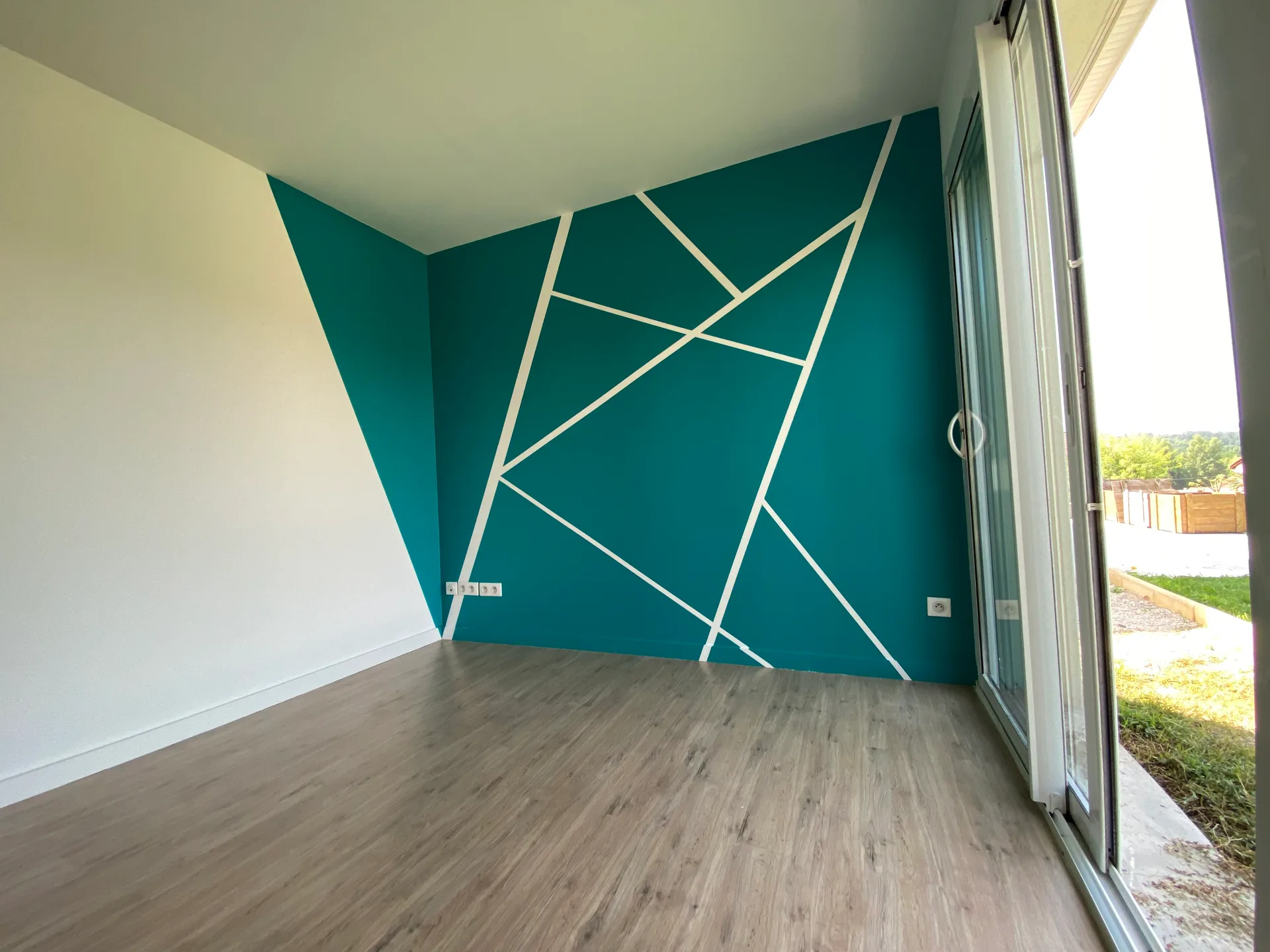 Mur bleu-vert et lignes géométriques blanches réalisés par GM Peinture à Bas-en-Basset